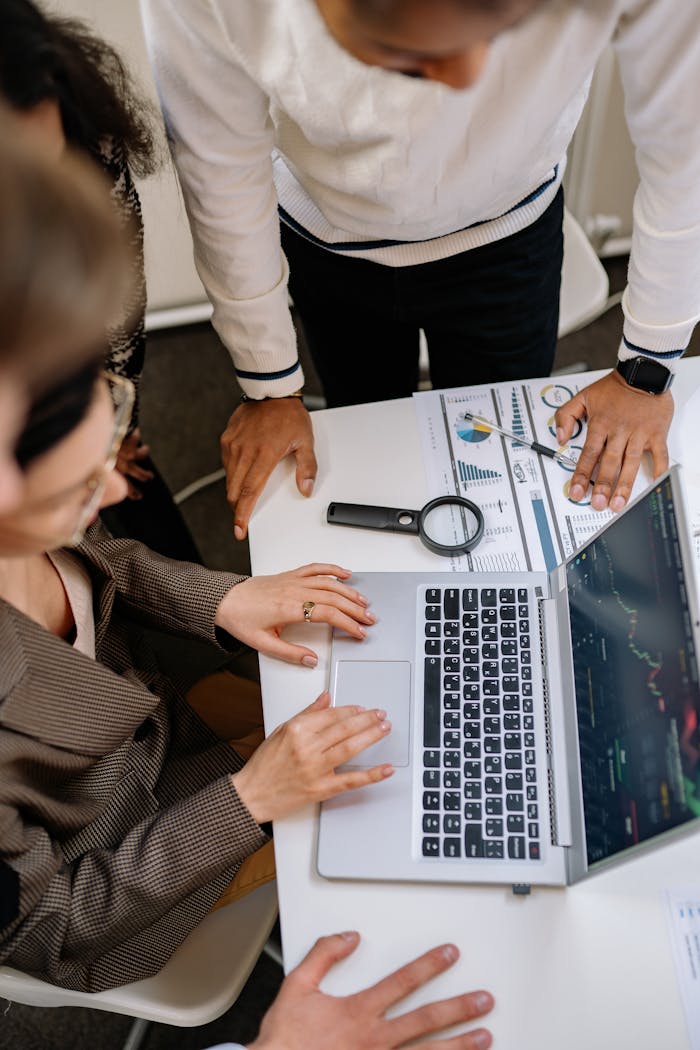 Top View of Coworkers Gathered around a Laptop